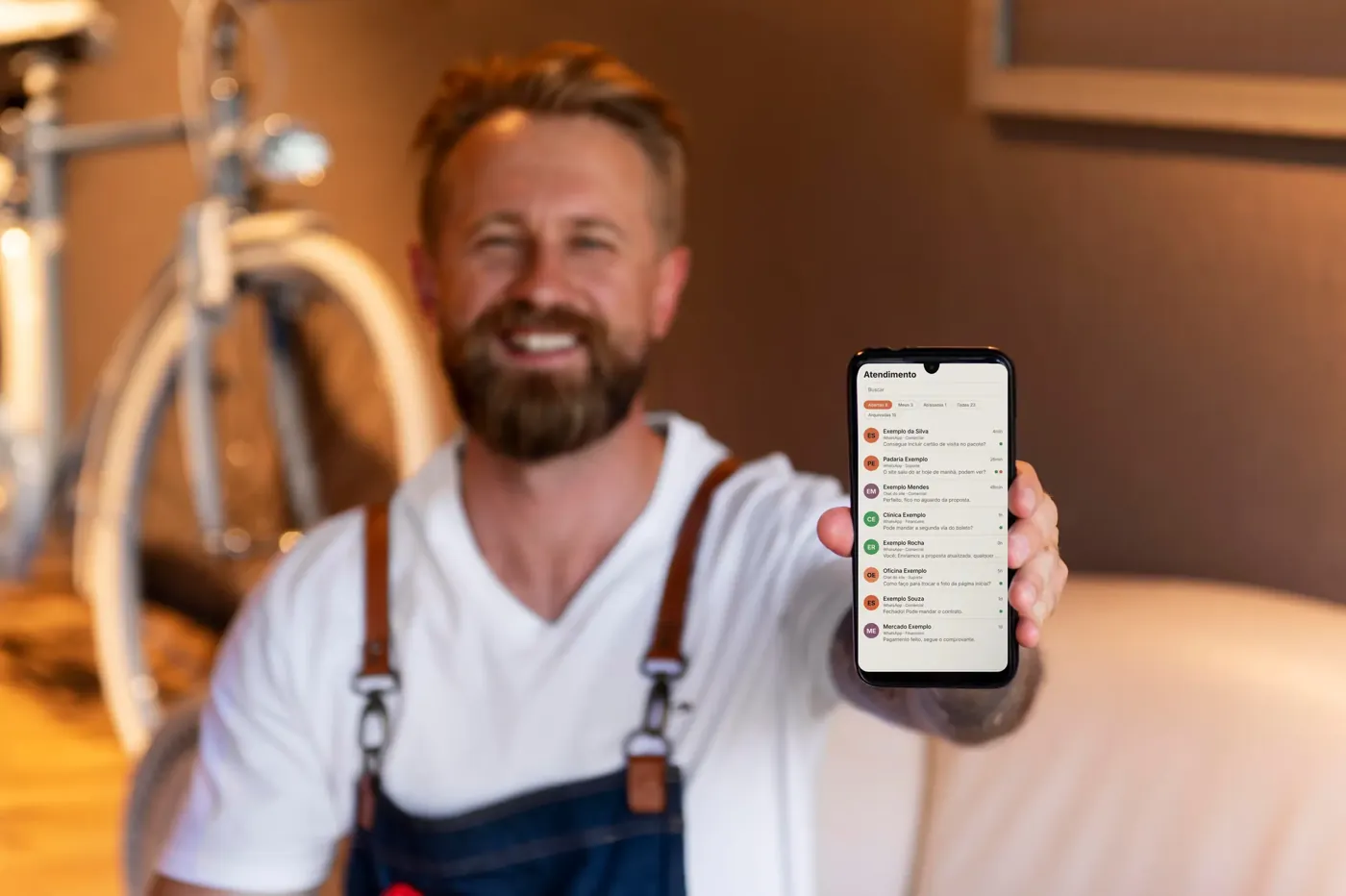Empresário mostrando a central de atendimento da Pense Moderno no celular